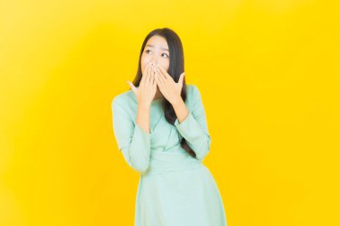 Portre güzel Asyalı kadın gülümsüyor. Renkli arka planda hareket var.