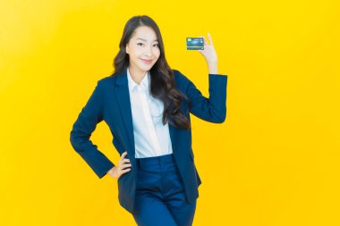 Güzel bir Asyalı kadının portresi. Renkli kredi kartıyla gülüyor.