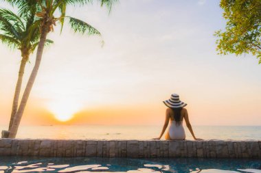 Güzel Asyalı genç kadınların portresi. Mutlu bir gülümseme. Kokteyl bardağıyla otel havuzunun etrafında rahatla.