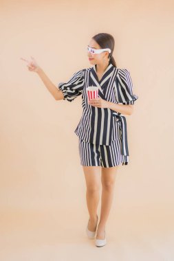 Kahverengi arka planda 3D gözlüklü güzel Asyalı kadın portresi.