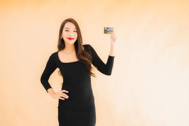 Renkli arka planda alışveriş yapmak için kredi kartı olan güzel bir Asyalı kadın portresi.