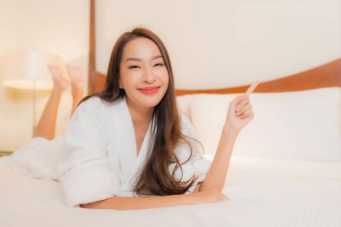 Güzel bir Asyalı kadının portresi. Gülümse. Yatak odasında rahatla.