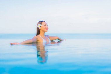 Güzel bir Asyalı kadın portresi. Rahat ol. Yüzme havuzu etrafında gülümse.