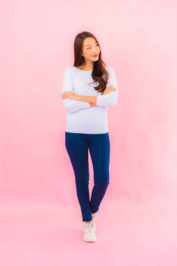 Portrait beautiful young asian woman smile with action on pink isolated background