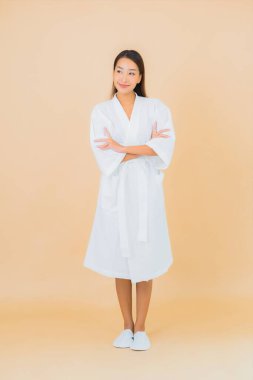 Güzel bir Asyalı kadın portresi. Üzerinde gülücük olan bir bornoz giyiyor.