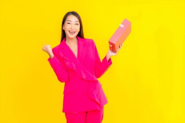 Sarı renkli, kırmızı hediye kutusu olan güzel Asyalı kadın portresi.