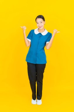 Güzel bir Asyalı kadın portresi ve sarı arka planda hareketli bir gülümseme.