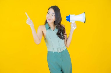 Güzel bir Asyalı kadının portresi. Arka planda megafonla gülümsüyor.