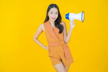 Güzel bir Asyalı kadının portresi. Arka planda megafonla gülümsüyor.