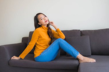 Genç Asyalı kadının portresi mutlu. Rahat ol. Koltukta gülümse.