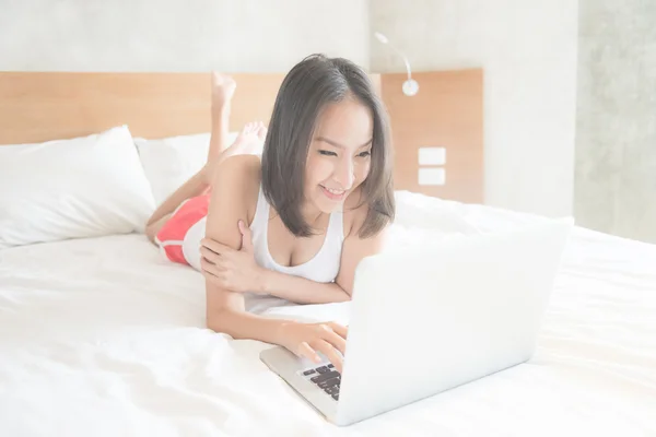 Жінка використовує комп'ютер у спальні — стокове фото