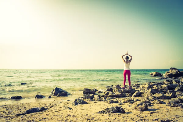 Donna azione yoga sulla spiaggia — Foto Stock