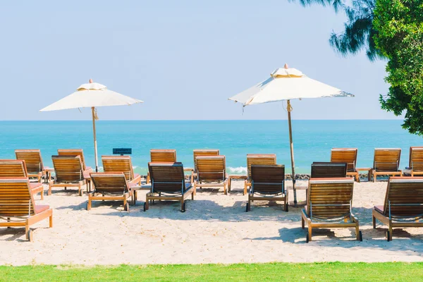 Umbrellas pool and chairs on beach — Stock Photo, Image