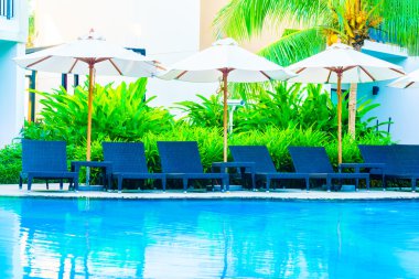 Şemsiyeleri ve sandalyeler Yüzme Havuzu etrafında