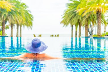 Otel havuzunda şapkalı kadın