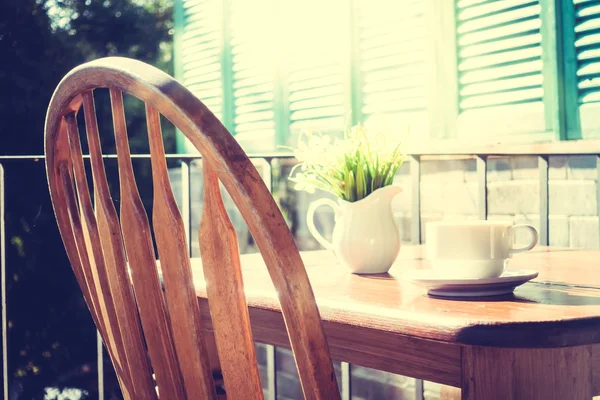 Kawy kubek i wazon roślin na stole — Zdjęcie stockowe