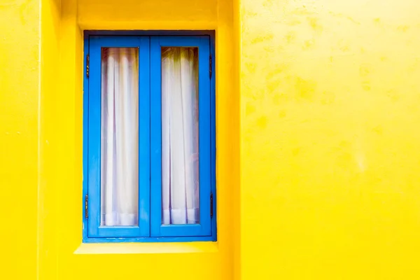 Janela azul na parede amarela — Fotografia de Stock