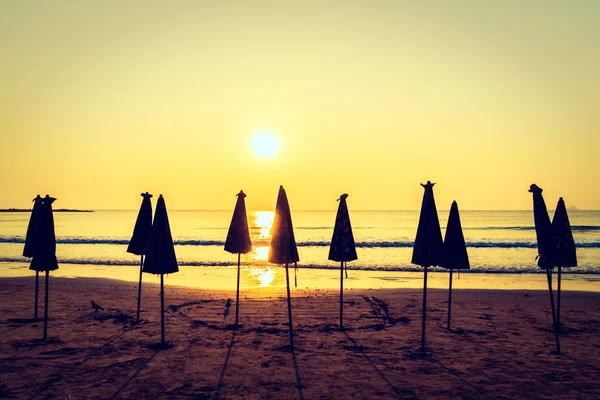 Guarda-chuvas de silhuetas em praia e mar — Fotografia de Stock