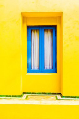 Sarı duvardaki mavi pencere