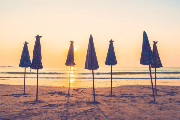 Lindas silhuetas guarda-chuvas na praia — Fotografia de Stock