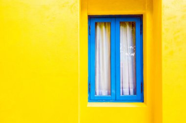 Sarı duvardaki mavi pencere
