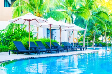 Şemsiyeleri ve sandalyeler etrafında hotel Yüzme Havuzu