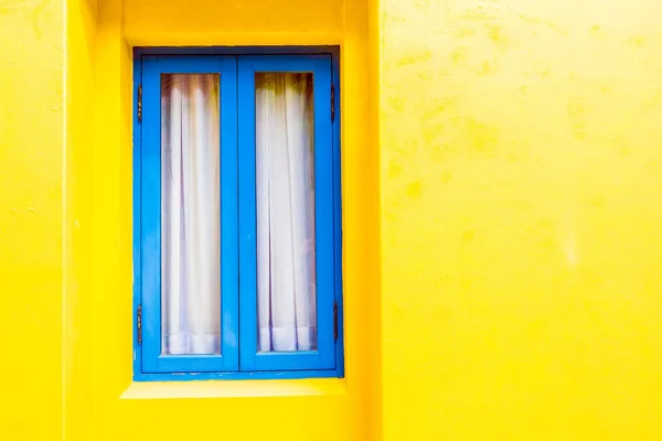 Janela azul na parede amarela — Fotografia de Stock