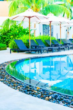 Şemsiyeleri ve sandalyeler etrafında hotel Yüzme Havuzu