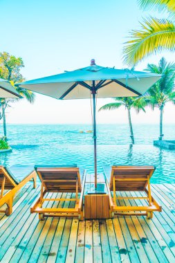 Şemsiyeleri ve sandalyeler Yüzme Havuzu etrafında