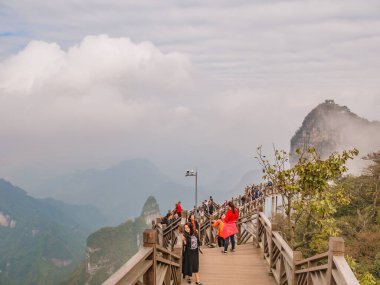 zhangjiajie / Çin - 15 Ekim 2018: Hunan şehrinin Çin kenti Zhangjiajie 'deki Tianmen Dağı ulusal parkında tahta köprüde yürüyen yabancı turistler.