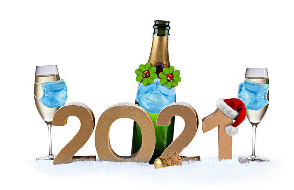 В канун Нового года коронавирус covid-19 распространился по всему миру. 2021 номер четыре листья клевера бутылки шампанского бокал с пандемической дыхательной маской изолированы на белом фоне