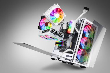 Cam pencereli ve gökkuşağı rgb LED ışıkları olan beyaz oyun bilgisayarının patlamış görüntüsü. Uçan donanım bileşenleri gri arkaplan üzerinde soyut teknoloji kavramı