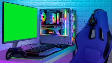 Renkli parlak ışıklı rgb oyun bilgisayarı klavye fare monitörü ve LED ışıklı tuğla duvarın önünde yarışan sandalyeli. Bilgisayar donanım oyunları oynuyor