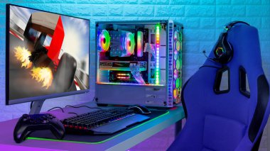 Renkli parlak ışıklı rgb oyun bilgisayarı klavye fare monitörü ve LED ışıklı tuğla duvarın önünde yarışan sandalyeli. Bilgisayar donanım oyunları oynuyor