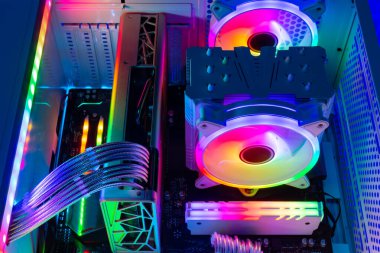 Inside view of custom colorful illuminated bright rainbow RGB LED gaming pc.. Computer power hardware and technology concept background clipart