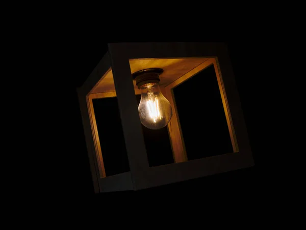 Varm Gul Glödande Glödlampa Innesluten Trälåda Mot Svart Bakgrund — Stockfoto