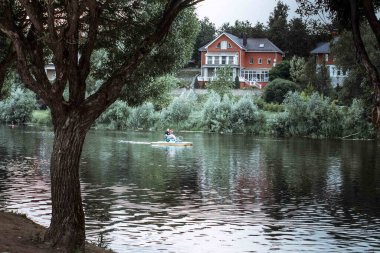 Nehir kenarındaki ev. Nehir kenarındaki bir binanın yaz fotoğrafı.
