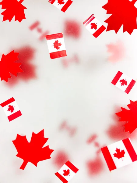 July 1, Happy Canada Day. Red maple leaves and flags on a transparent foggy background. A multi-tiered photo, a Memorial day card. The concept of freedom and patriotism, independence and victory. High quality photo