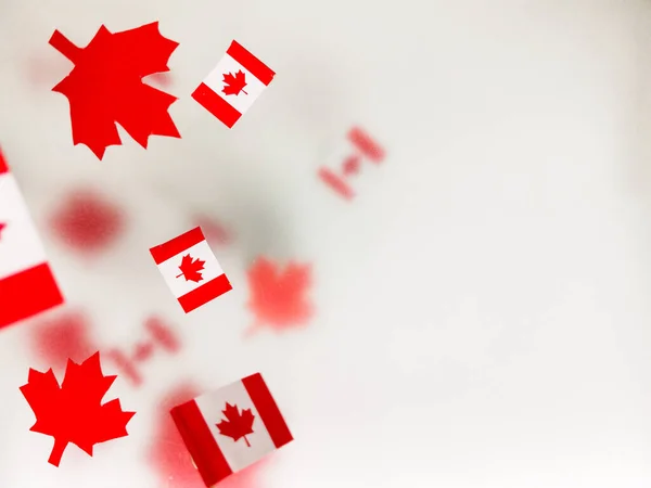 July 1, Happy Canada Day. Red maple leaves and flags on a transparent foggy background. A multi-tiered photo, a Memorial day card. The concept of freedom and patriotism, independence and victory. High quality photo