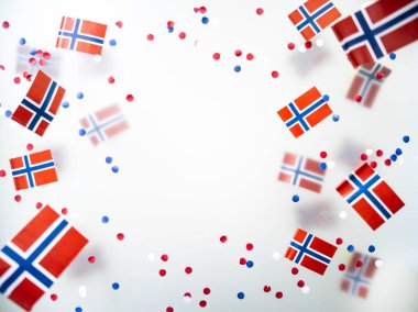 Norwegian independence day, Constitution day, may 17. holiday of freedom, victory and memory. concept of patriotism and faith. paper confetti and mini flags on white foggy background. High quality photo clipart