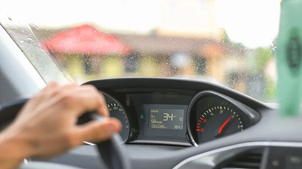 Hombre conduciendo un coche a través de la aldea Imágenes de stock libres de derechos