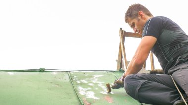 Adam çatıda Sandering boya çalışma