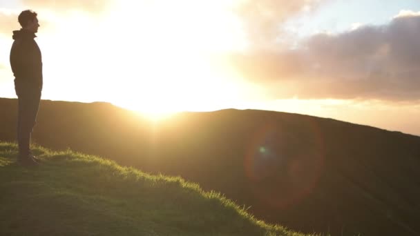 Hombre mirando el atardecer, cámara panorámica al fondo — Vídeo de stock