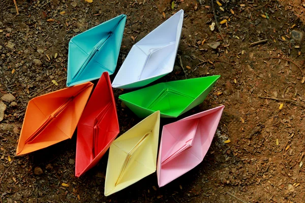 Colorful paper boats on barren land — Stock Photo, Image