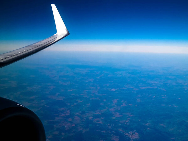 View from plane window on Planet Earth, plane enginie and wing. Travel and transport concept.