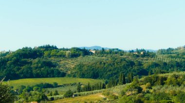 Tepeler, tarlalar ve çayırlar - tipik Toskana manzarası, İtalya. Seyahat, doğa ve tarım kavramı. Güneşli bir sonbahar günü, İtalya 'da tatiller. Boşluğu kopyala.