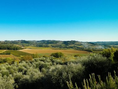 Tepeler, tarlalar ve çayırlar - tipik Toskana manzarası, İtalya. Seyahat, doğa ve tarım kavramı. Güneşli bir sonbahar günü, İtalya 'da tatiller. Boşluğu kopyala.