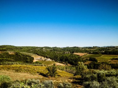 Tepeler, tarlalar ve çayırlar - tipik Toskana manzarası, İtalya. Seyahat, doğa ve tarım kavramı. Güneşli bir sonbahar günü, İtalya 'da tatiller. Boşluğu kopyala.