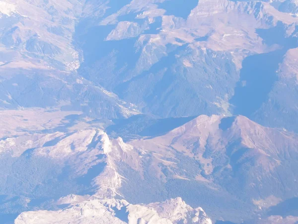 Alpler, uçağın penceresinden dağların manzarası. Toprak bükme ve doğa kavramı.