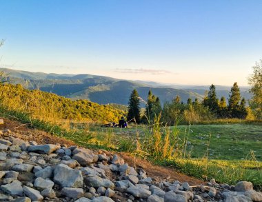 Beskids 'da bir çayırda dinlenen bir bisikletçi. Kuzey Polonya.